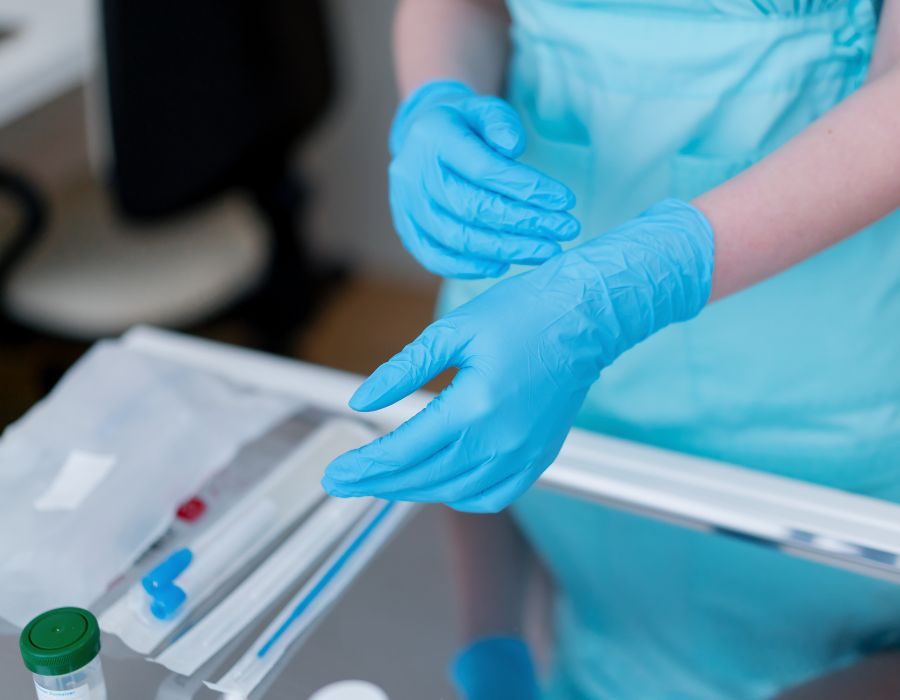 Gloved hands preparing a vaccine syringe