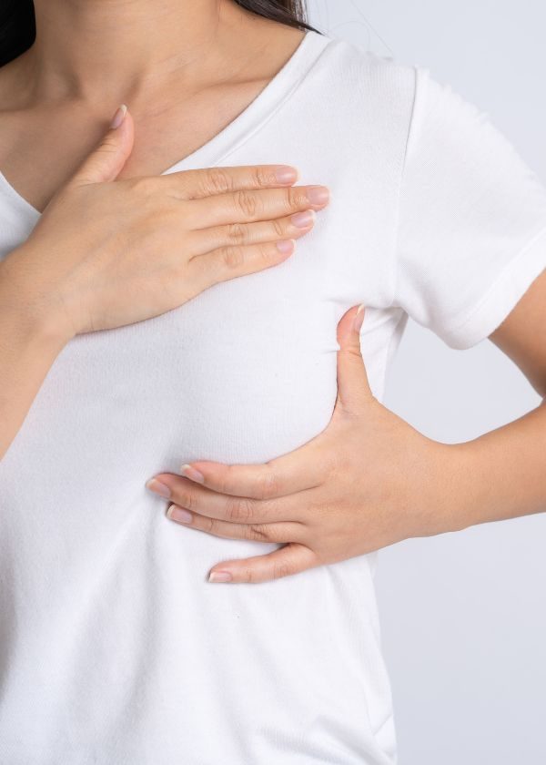 Woman performing breast self-examination