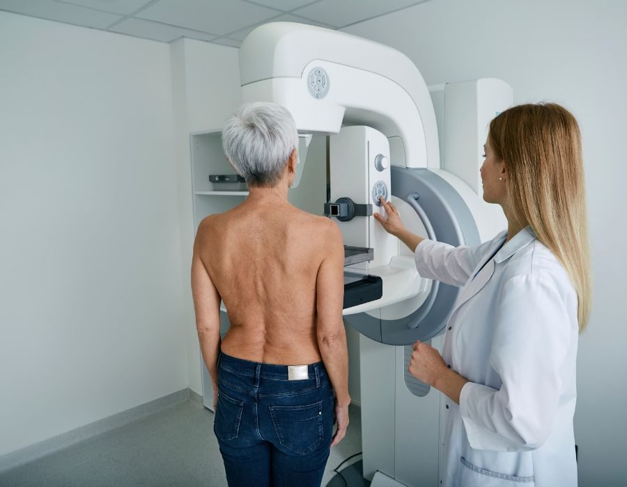 Patient positioned at a mammography unit with a radiographer